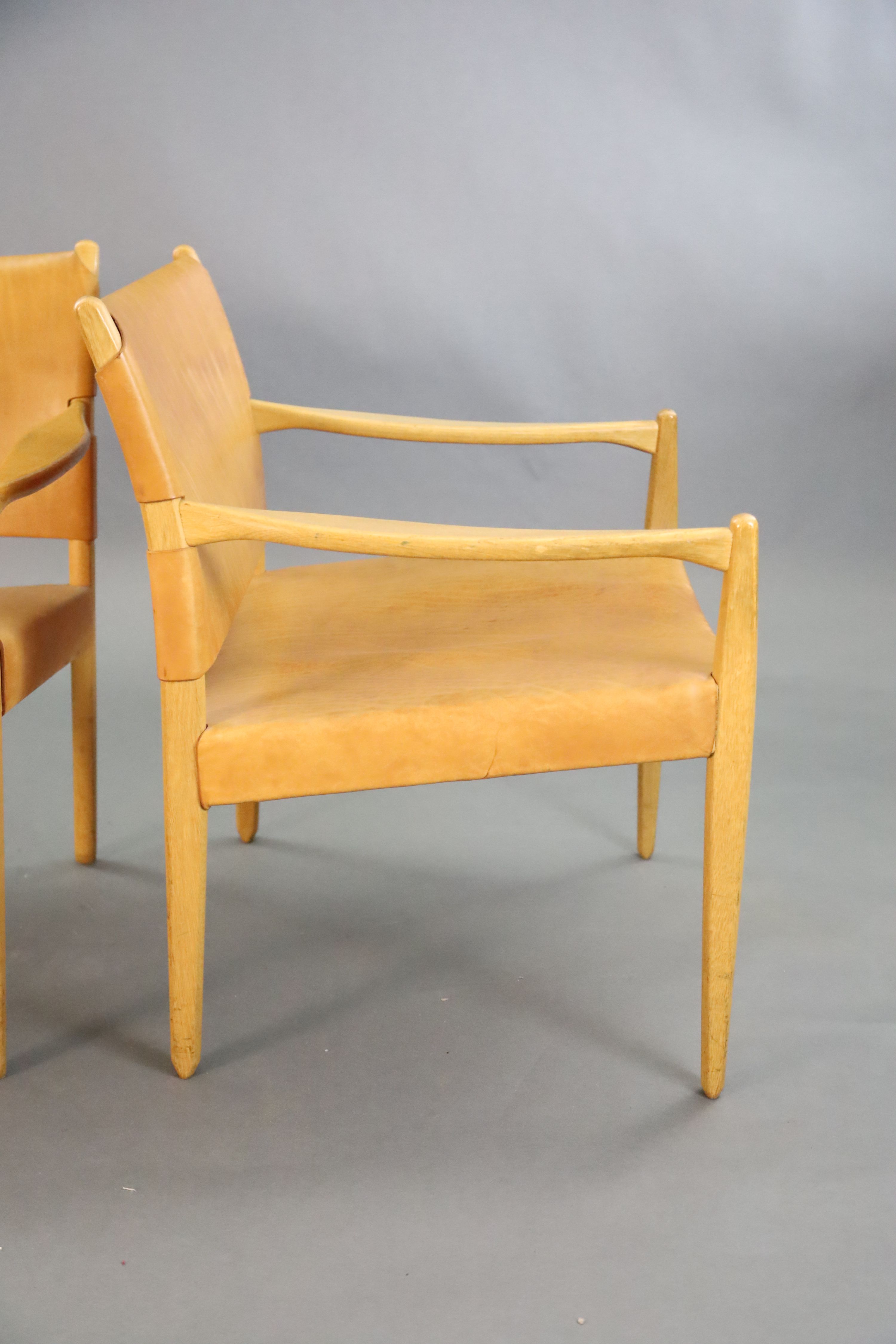 A pair of Swedish Varufakta tan leather and golden oak armchairs, W.2ft 1in. D. 2ft 1in. H.2ft 4in.